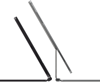 อุปกรณ์ iPad Pro จำนวน 2 เครื่องที่ติดเข้ากับ Magic Keyboard, ตัวเครื่องภายนอกด้านข้าง, รูปทรงที่บาง, สีดำสเปซแบล็ค พร้อมลำโพงและพอร์ต USB-C, เอียงเปิดครึ่งหนึ่ง, สีเงิน, เปิดกางอยู่, เอียงไปด้านหลังเพื่อแสดงดีไซน์แบบยกลอยที่ปรับเอนได้ของคีย์บอร์ด, ลำโพง และไมโครโฟน